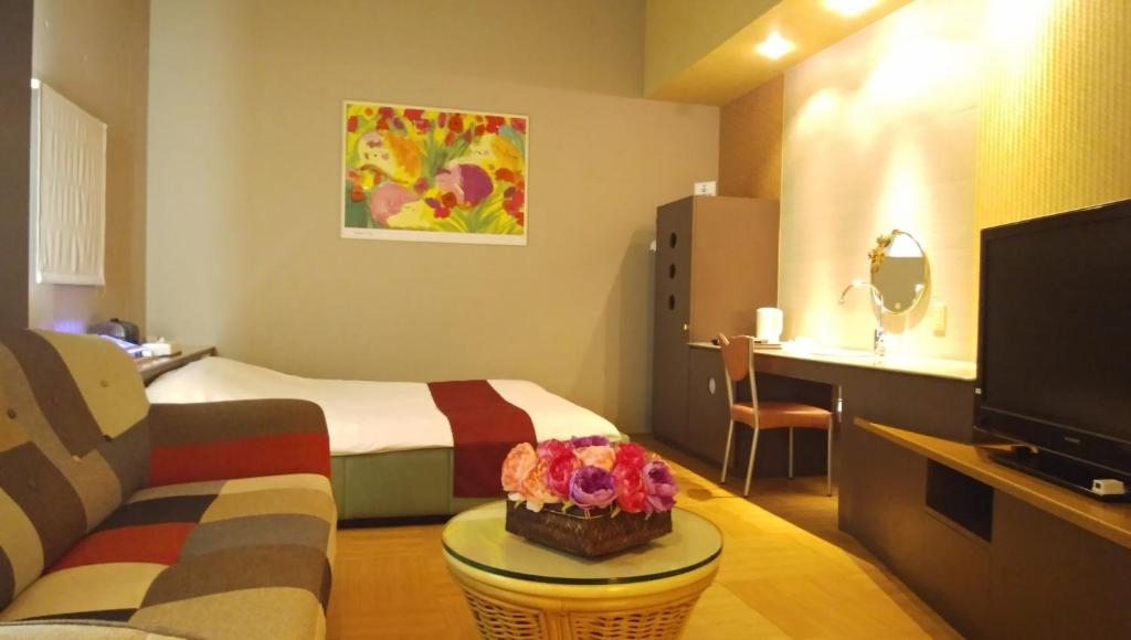 une chambre d'hôtel avec un lit et une télévision dans l'établissement LA.FESTA (Adult Only), à Takamatsu