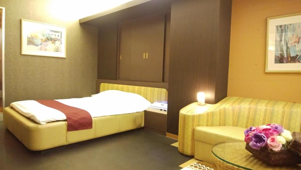 - une chambre avec un lit et une table avec une bougie dans l'établissement LA.FESTA (Adult Only), à Takamatsu