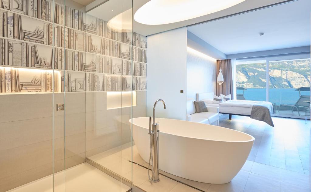 une salle de bain avec baignoire et une chambre dans l'établissement Hotel Castello Lake Front, à Malcesine 41 autres photos