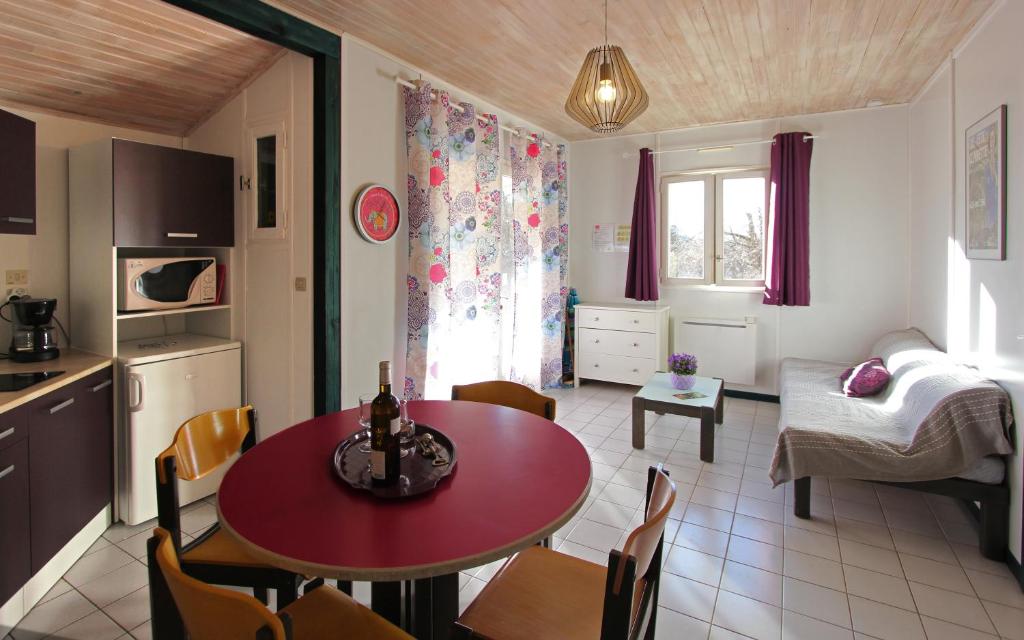une cuisine et une salle à manger avec une table et des chaises rouges dans l'établissement Chanteduc, à Beaurières