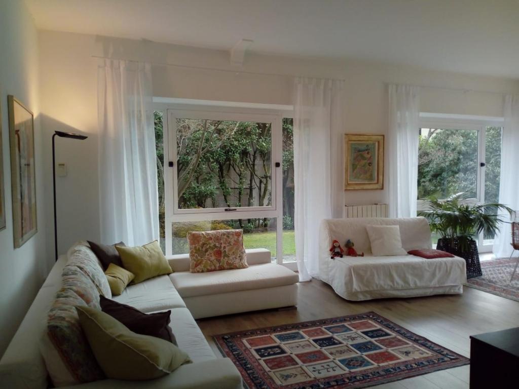 un salon avec deux canapés blancs et une fenêtre dans l'établissement Villa Alice, à Lesa