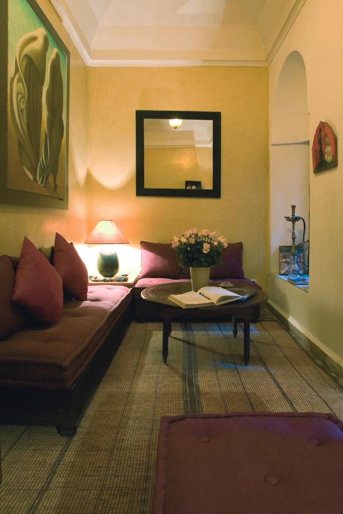 un salon avec un canapé et une table dans l'établissement Dar Attajmil, à Marrakech