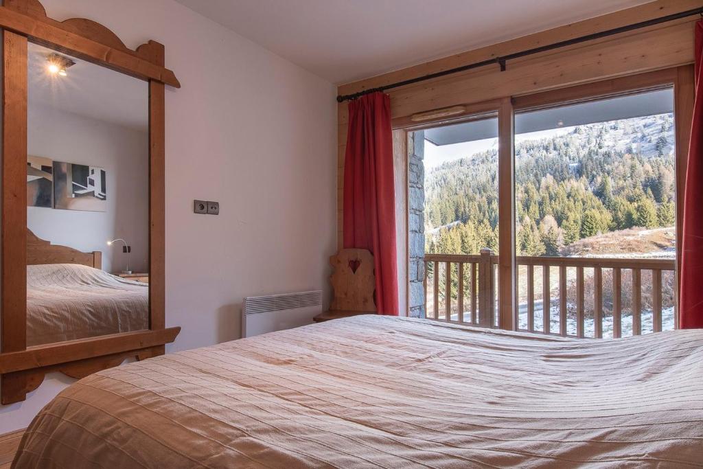une chambre avec un lit et une grande fenêtre dans l'établissement Arc 1800 Alpage du chantel Iseran SKI-in SKI-out, à Arc 1800