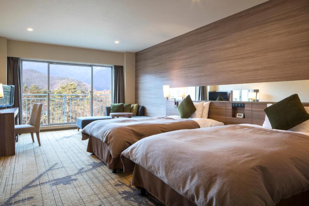 une chambre d'hôtel avec deux lits et une grande fenêtre dans l'établissement Fuji View Hotel, à Fujikawaguchiko