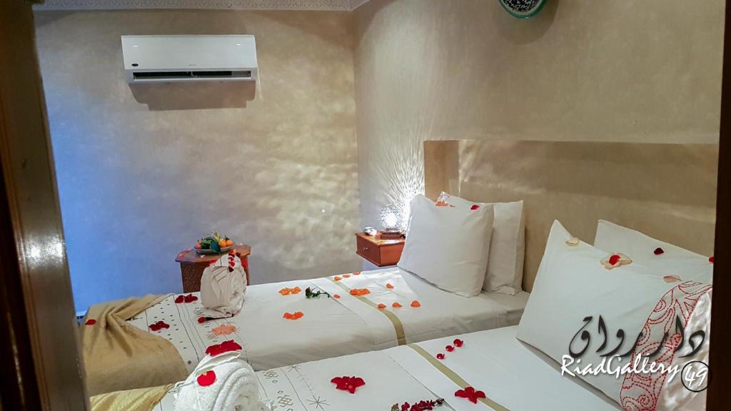 - une chambre dotée d'un lit avec des draps blancs et des fleurs dans l'établissement Riad Gallery 49 & Spa, à Marrakech