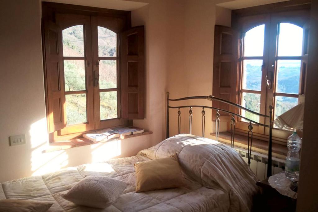 - un lit dans une chambre avec 2 fenêtres dans l'établissement Villa Armonia, à Borgo a Mozzano 47 autres photos
