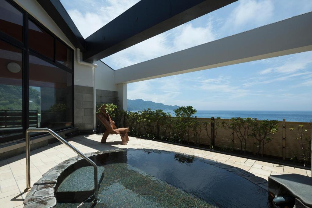 - une piscine dans une maison avec vue sur l'océan dans l'établissement Arujisu, à Izu