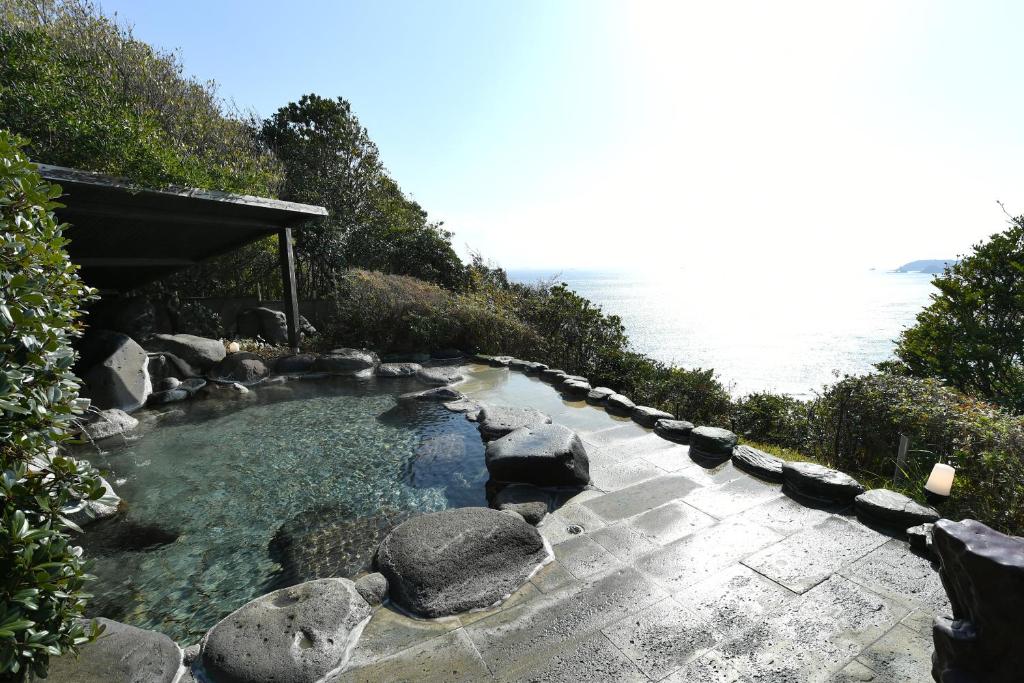 - un bain à remous avec des rochers dans l'eau dans l'établissement Shimoda Yamatokan, à Shimoda