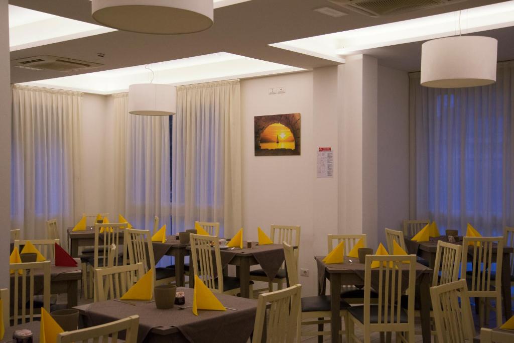 une salle à manger avec des tables et des chaises jaunes dans l'établissement Hotel Villa Enea, à Cattolica
