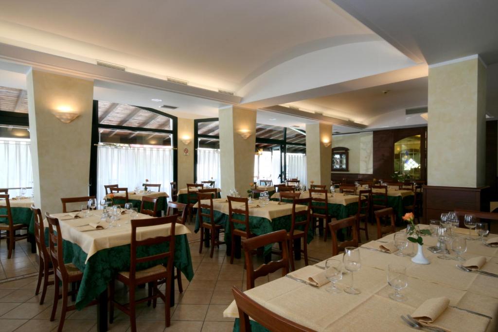 un restaurant avec tables et chaises et nappes vertes dans l'établissement Hotel Al Fogo, à Bevazzana