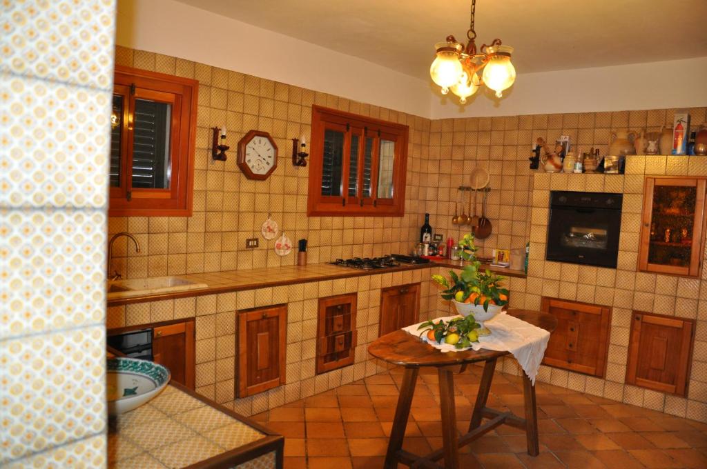 une cuisine avec une table au milieu dans l'établissement Corso's old nest a mille metri dalla spiaggia guida loca, à Castellammare del Golfo