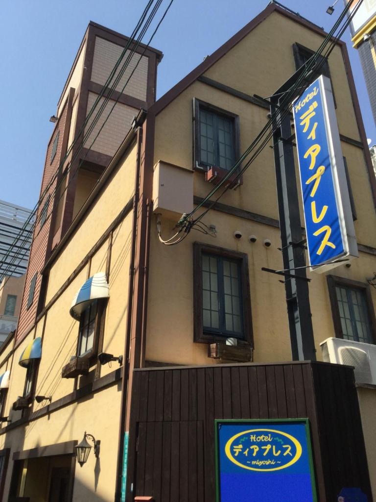 un bâtiment avec une enseigne devant lui dans l'établissement Dear Place(Adult Only), à Osaka
