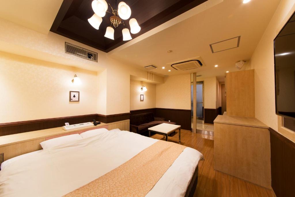 une chambre avec un grand lit et une télévision dans l'établissement Hotel Luna Sakuranomiya (Adult Only), à Osaka