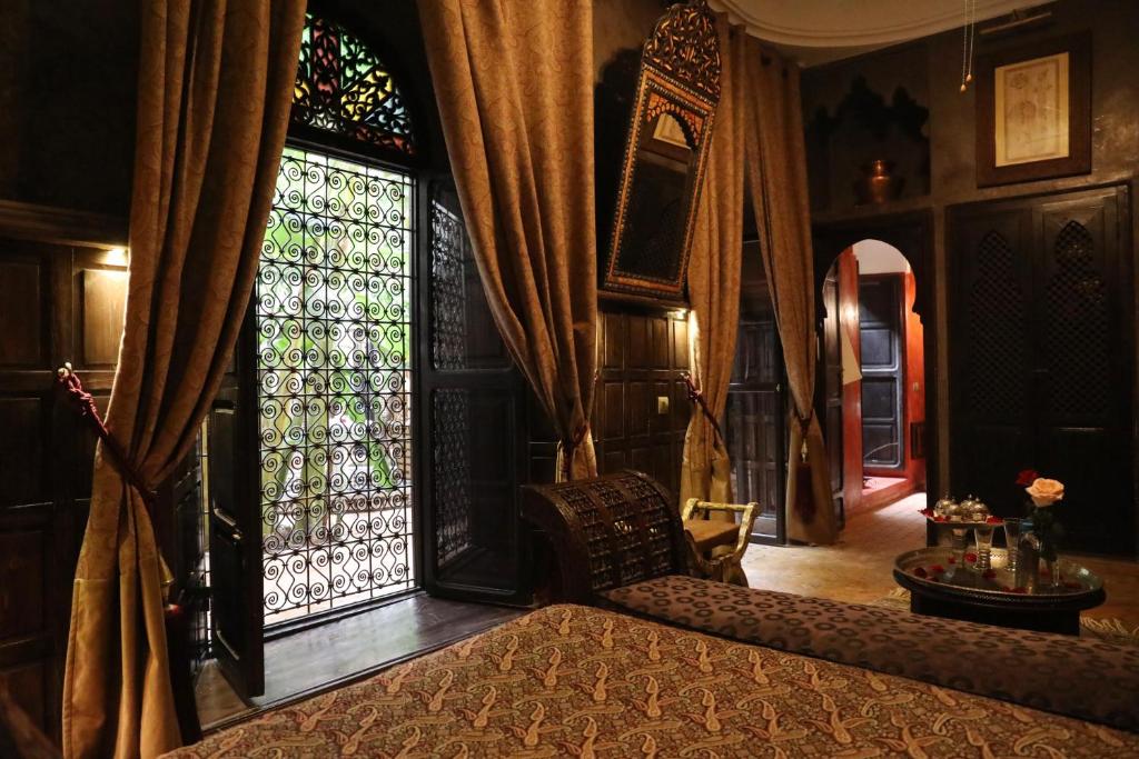 une chambre avec un lit et une grande fenêtre dans l'établissement Riad ILayka, à Marrakech