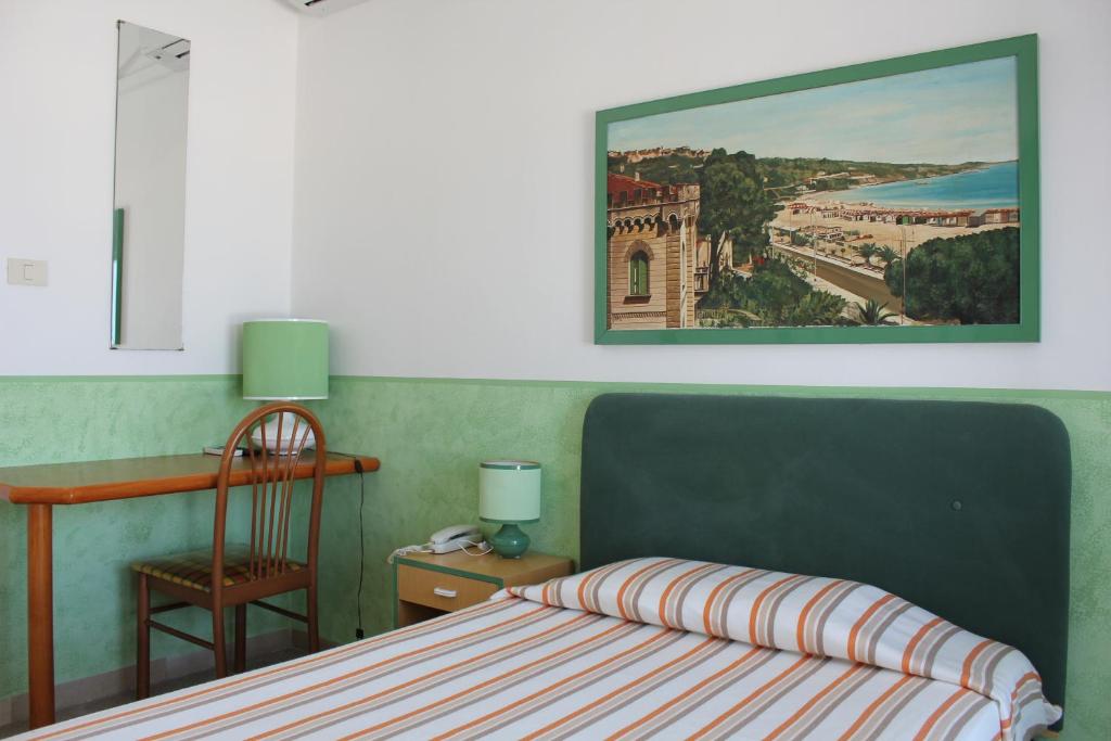 une chambre avec un lit, une chaise et un tableau dans l'établissement Hotel Venezia New, à Vasto