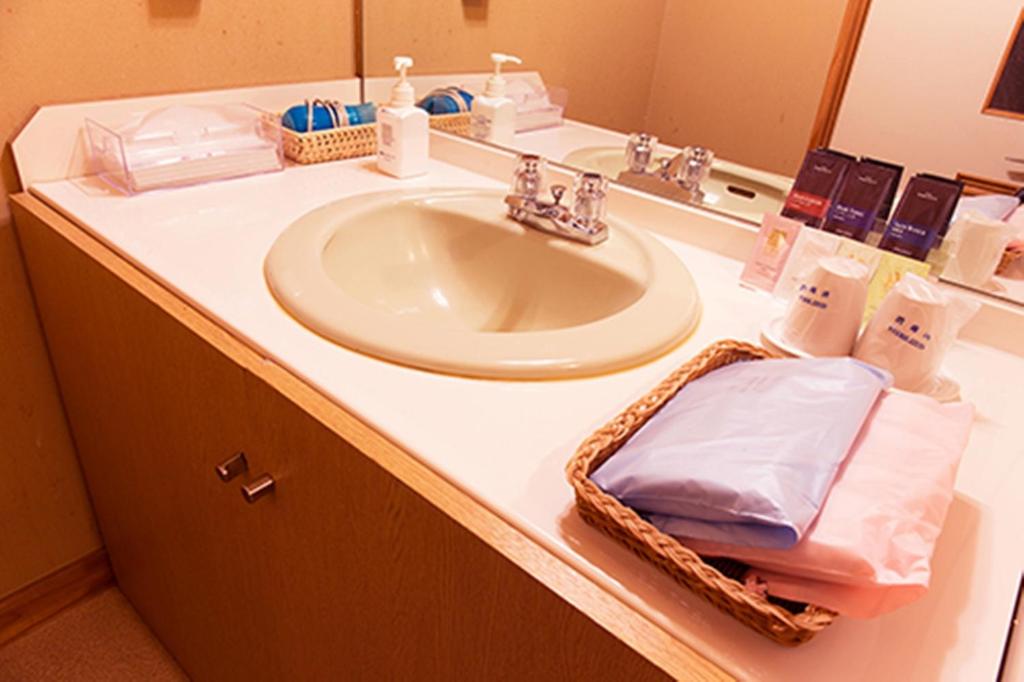 un comptoir de salle de bain avec un lavabo et un miroir dans l'établissement Ryuudo, à Minakami 52 autres photos