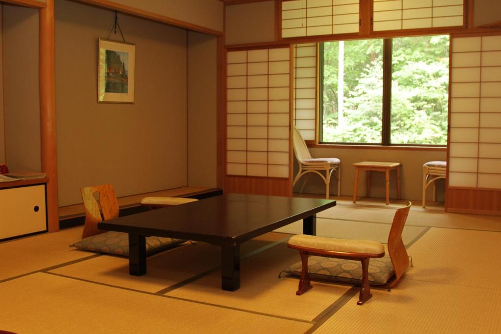 un salon avec une table et des chaises dans l'établissement Yamabiko, à Azumino