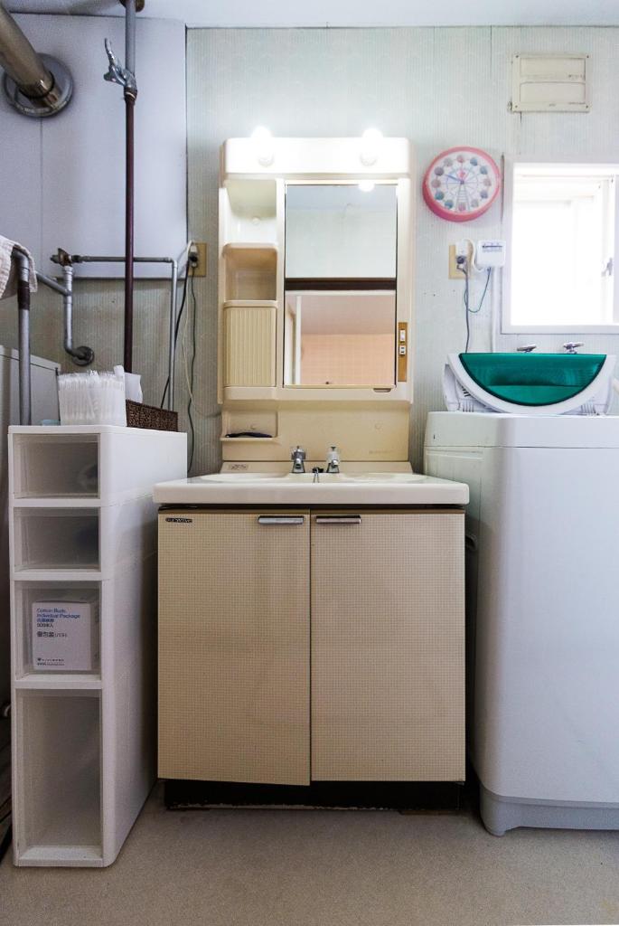 une salle de bain avec un lavabo et un miroir dans l'établissement Minshuku Nihonkai, à Ishikari