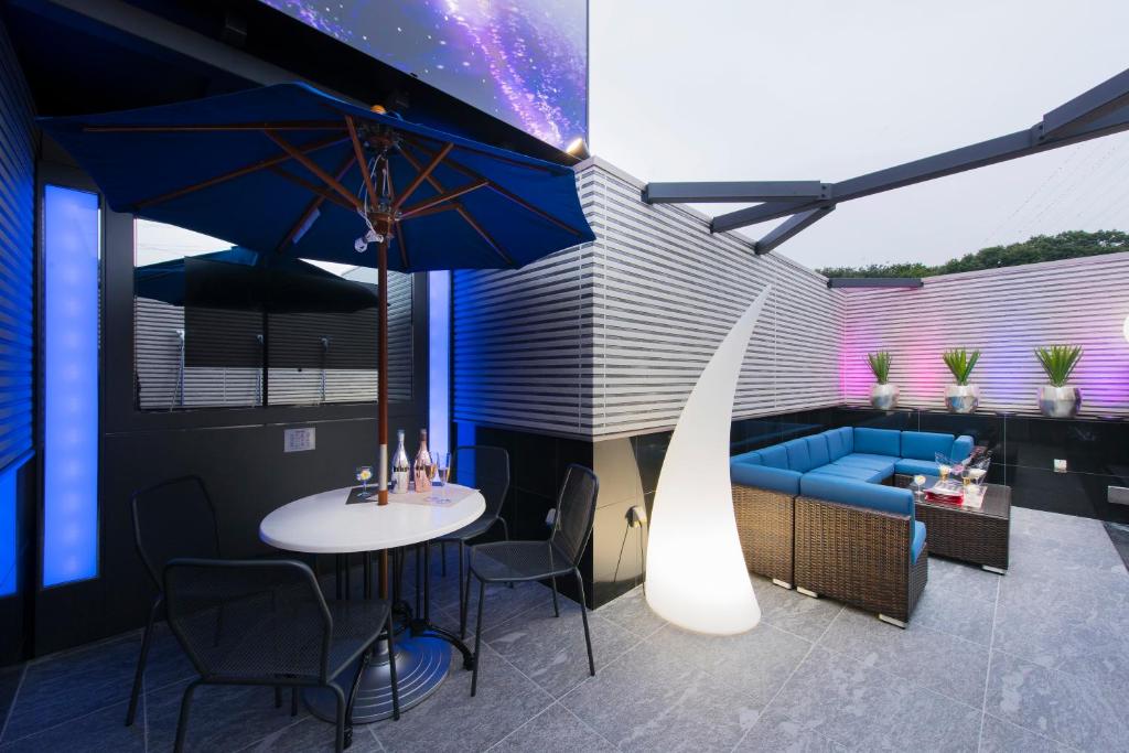 une terrasse avec une table et un canapé bleu dans l'établissement HOTEL W-PARTY-W GROUP HOTELS and RESORTS-, à Kawaguchi