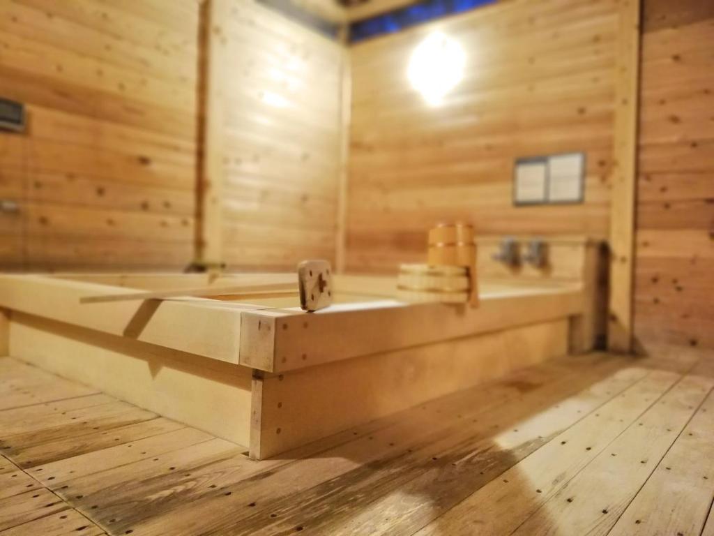 Cette chambre en bois comprend une salle de bains pourvue d'une baignoire. dans l'établissement Ishinoya Izunagaoka - TKP Hotels & Resorts, à Izunokuni