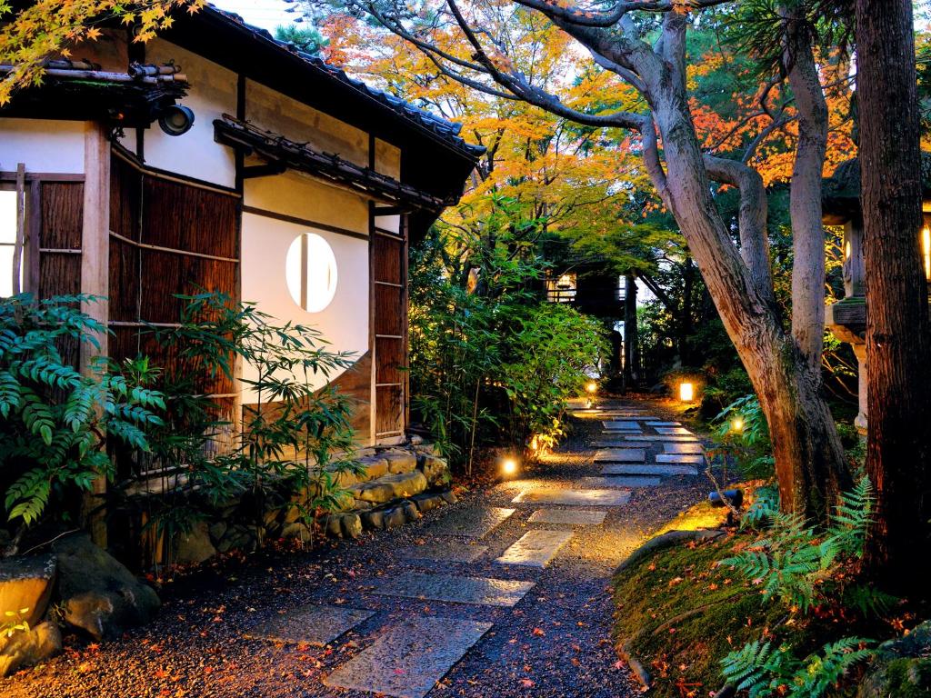 un chemin en pierre à côté d'une maison éclairée dans l'établissement Heihachi Tea House Inn, à Kyoto