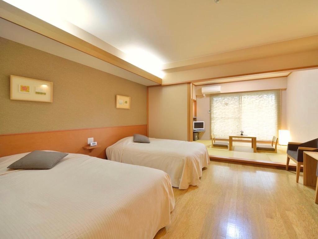 une chambre d'hôtel avec deux lits et une fenêtre dans l'établissement Mashikokan Satoyama Resort Hotel, à Mashiko 37 autres photos
