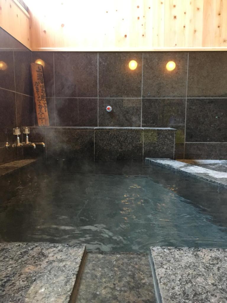 La salle de bains est pourvue d'une grande piscine d'eau. dans l'établissement Hoshi Meguri, à Shimoda