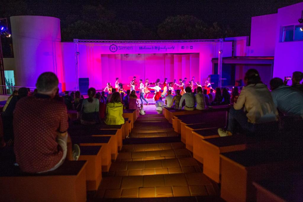 Un groupe de personnes assises sur des bancs qui assistent à un spectacle dans l'établissement TH Simeri - Simeri Village, à Simeri Mare 23 autres photos