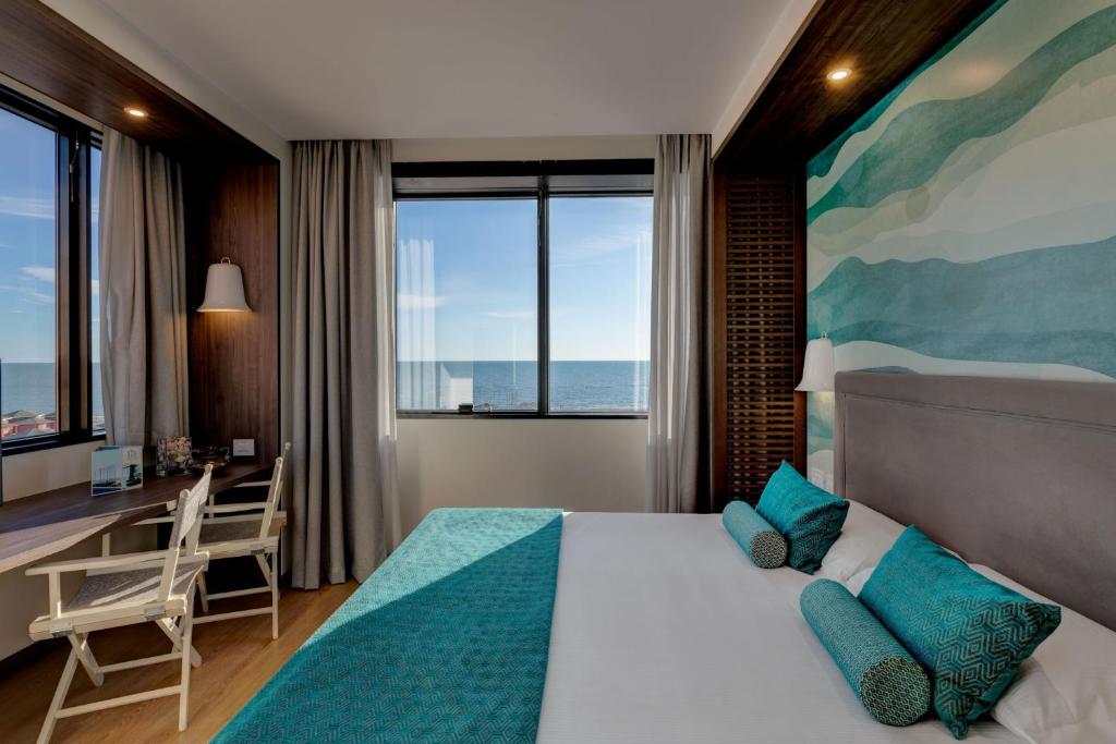 une chambre avec un lit avec un bureau et une fenêtre dans l'établissement Fly Decó Hotel, à Lido di Ostia