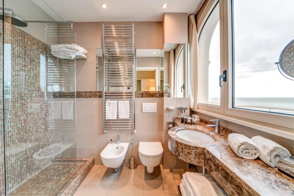une salle de bain avec un lavabo, des toilettes et une douche dans l'établissement Terrazza Marconi Hotel&Spamarine, à Senigallia