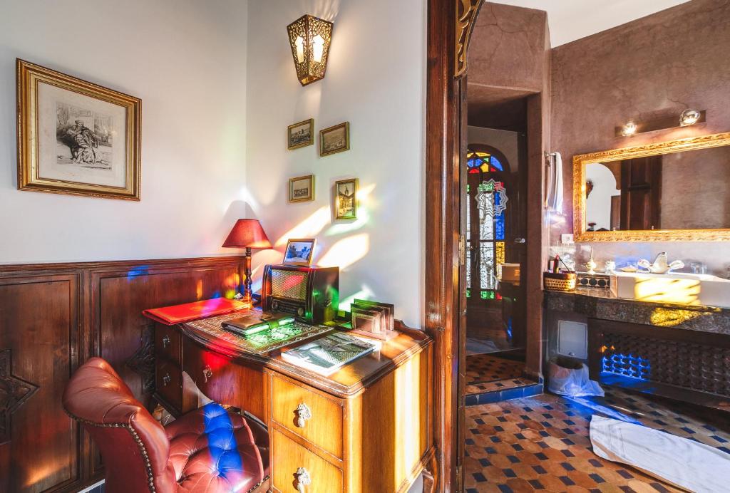 Cette chambre comprend un bureau avec une chaise et un miroir. dans l'établissement Riad Le Calife, à Fès