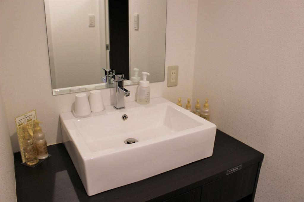 une salle de bain avec un lavabo blanc et un miroir dans l'établissement Pal Annex Oita (Love Hotel), à Ōita