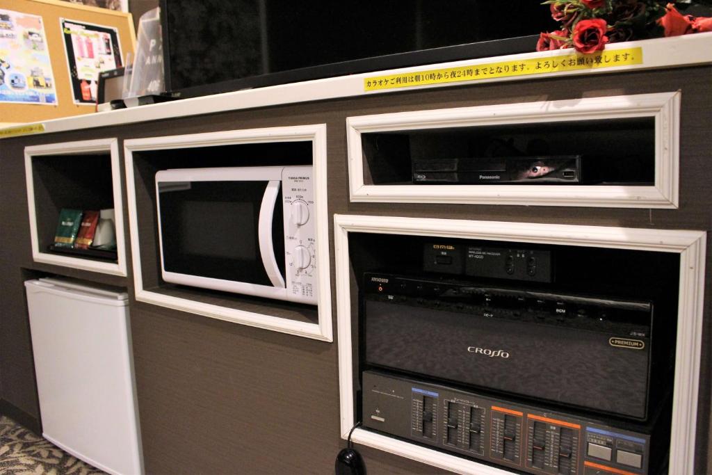 Trois fours micro-ondes sont installés sur une étagère dans l'établissement Pal Annex Oita (Love Hotel), à Ōita