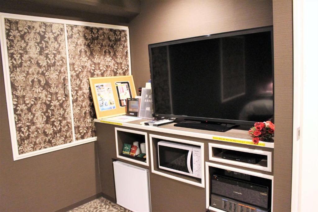 un salon avec une grande télévision à écran plat dans l'établissement Pal Annex Oita (Love Hotel), à Ōita 9 autres photos