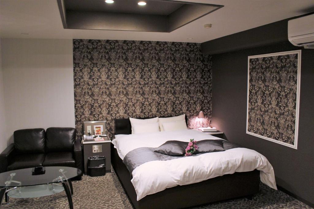 une chambre avec un grand lit et une chaise dans l'établissement Pal Annex Oita (Love Hotel), à Ōita