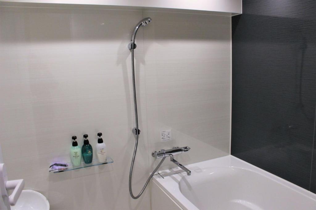 une douche dans une salle de bain avec une baignoire et un lavabo dans l'établissement Pal Annex Oita (Love Hotel), à Ōita