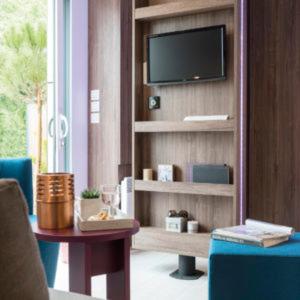 - un salon avec une télévision sur une étagère et une table dans l'établissement Camping Frédéric Mistral, à Castellane