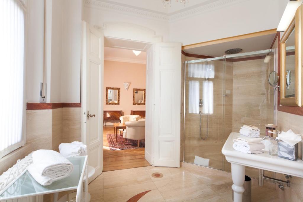une salle de bains avec douche, lavabo et miroir dans l'établissement Grand Hotel Rimini, à Rimini