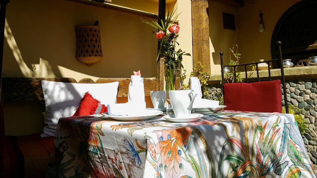 une table avec des assiettes et des tasses en haut dans l'établissement Riad Gallery 49 & Spa, à Marrakech