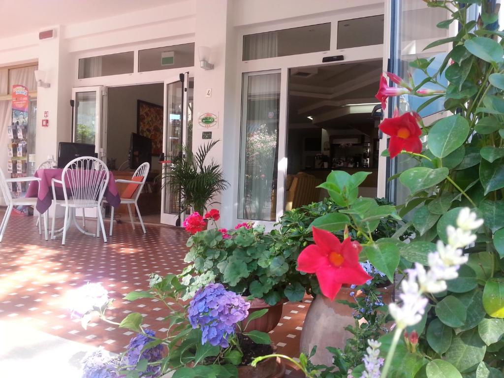 - une terrasse couverte avec des fleurs, une table et des chaises dans l'établissement Hotel St. Moritz, à Rimini