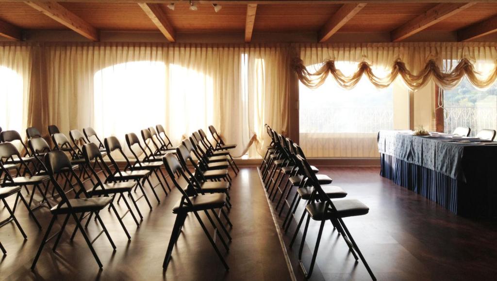 une chambre avec des rangées de chaises et une table dans une pièce dans l'établissement Hotel Villa Truentum, à Martinsicuro