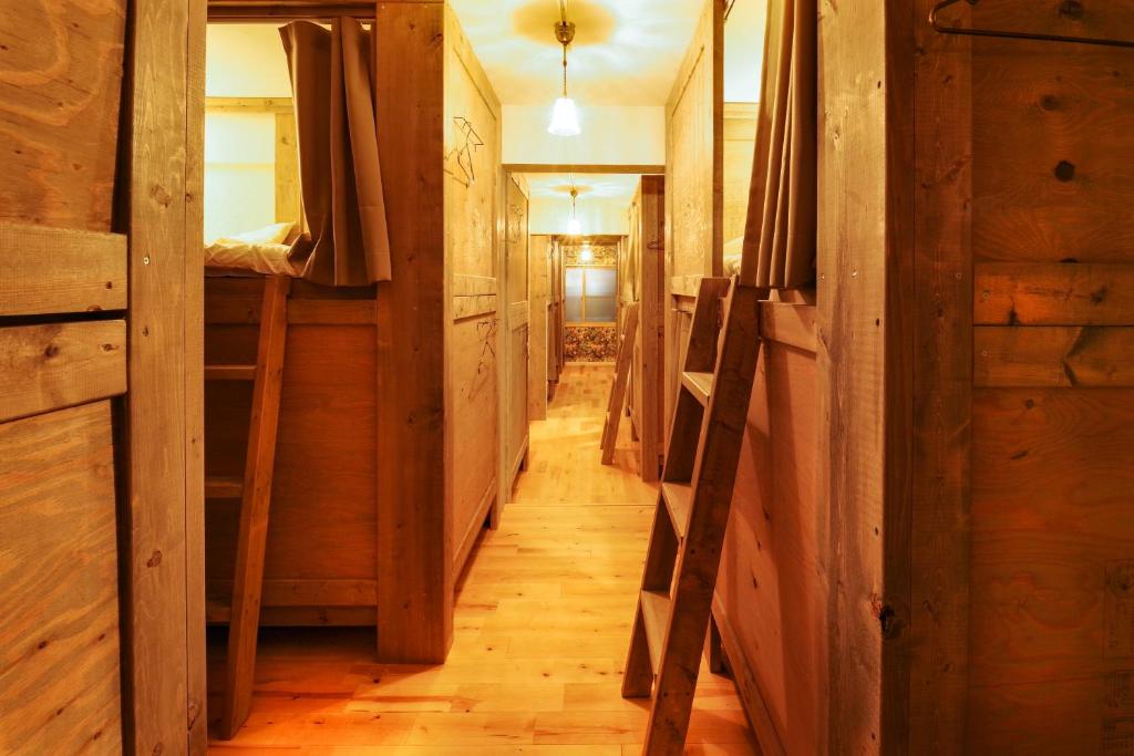 - un couloir dans une cabine dotée de parquet et de murs en bois dans l'établissement Shiretoko Village, à Shari