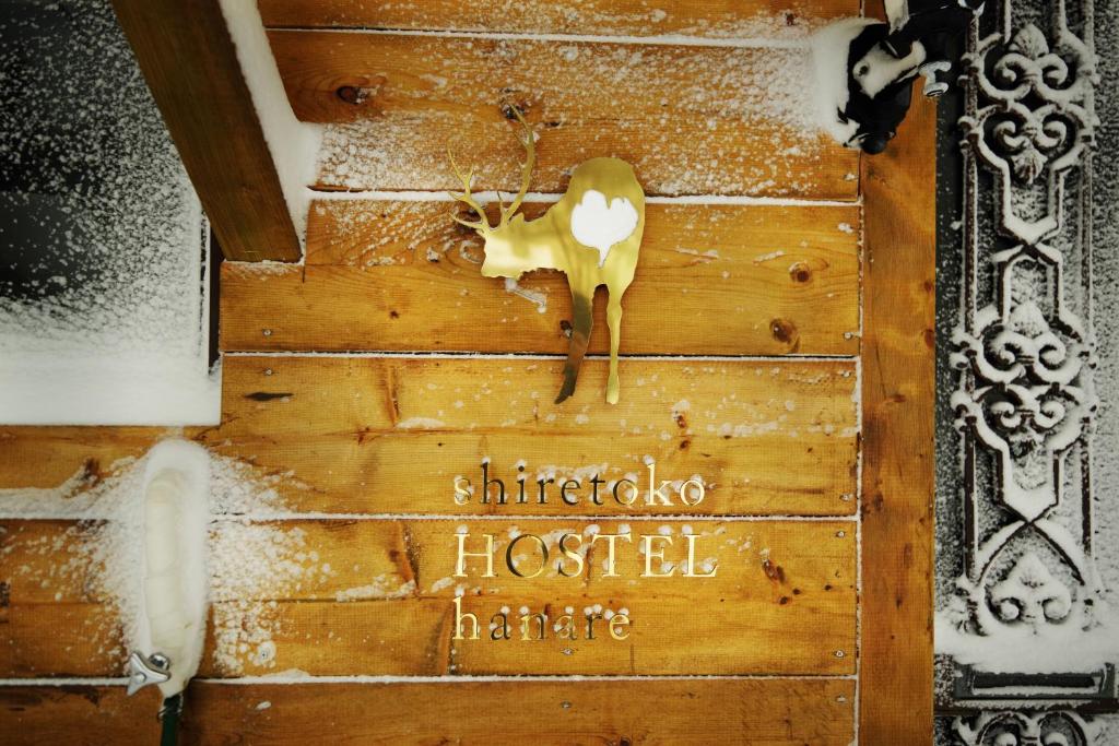 une porte en bois avec un cerf sur elle dans l'établissement Shiretoko Village, à Shari