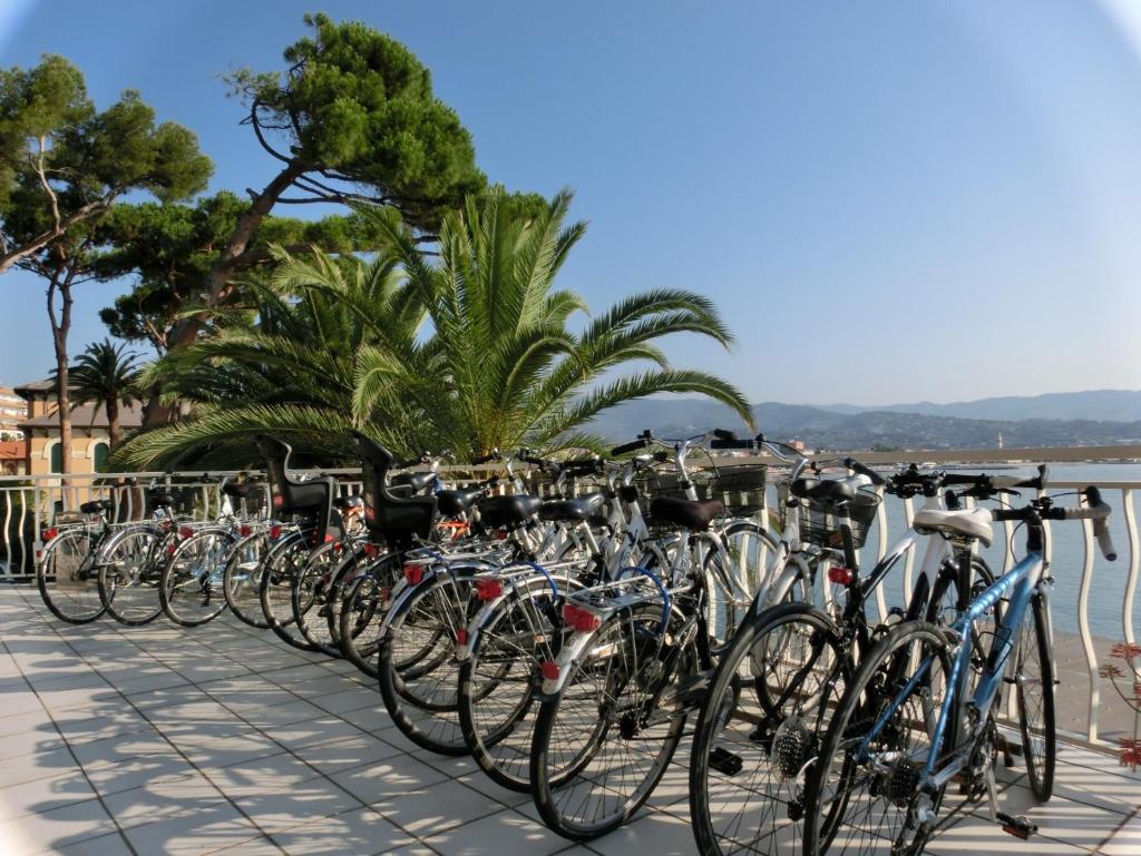 Une rangée de vélos garés à côté de l'eau dans l'établissement Hotel Arc En Ciel, à Diano Marina