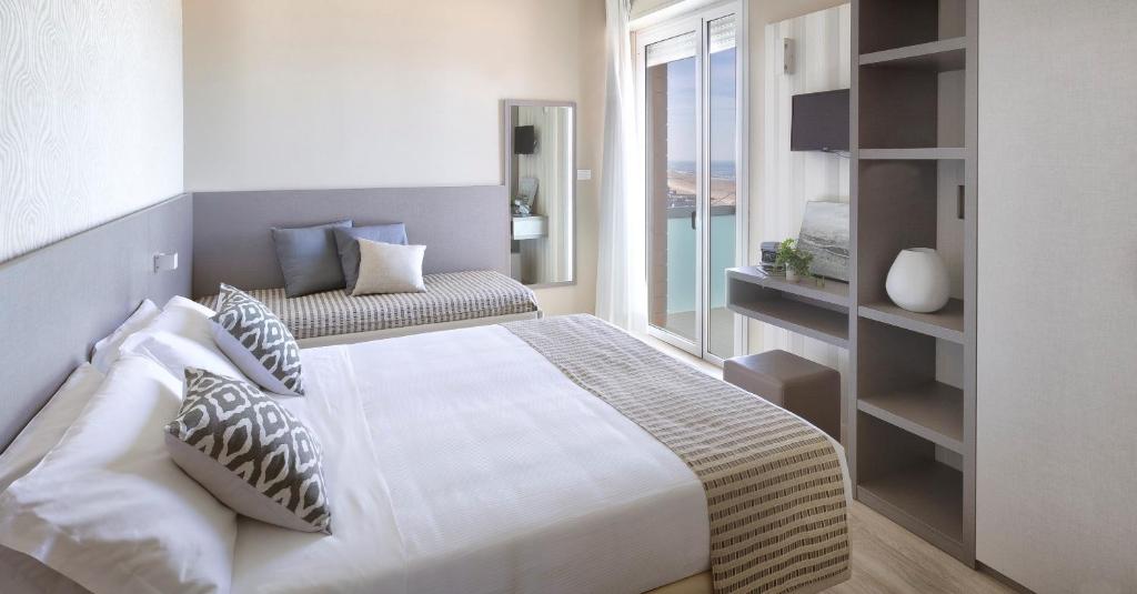 une chambre avec un grand lit blanc et une fenêtre dans l'établissement Little Hotel, à Riccione 103 autres photos