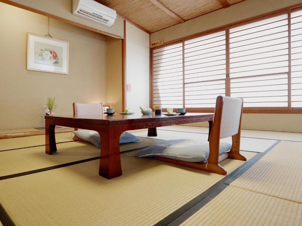 une salle à manger avec une table et des chaises en bois dans l'établissement Shibu Onsen KOKUYA, à Yamanouchi