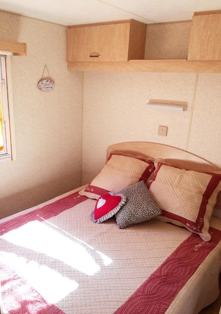 un lit avec des oreillers dessus dans une chambre dans l'établissement Mobil Home à la ferme, en Provence, à Grambois
