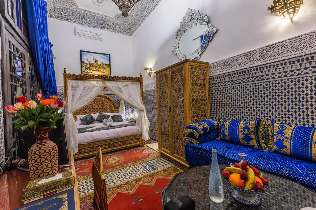 un salon avec un canapé et un lit dans l'établissement Riad Ghita Palace, à Fès