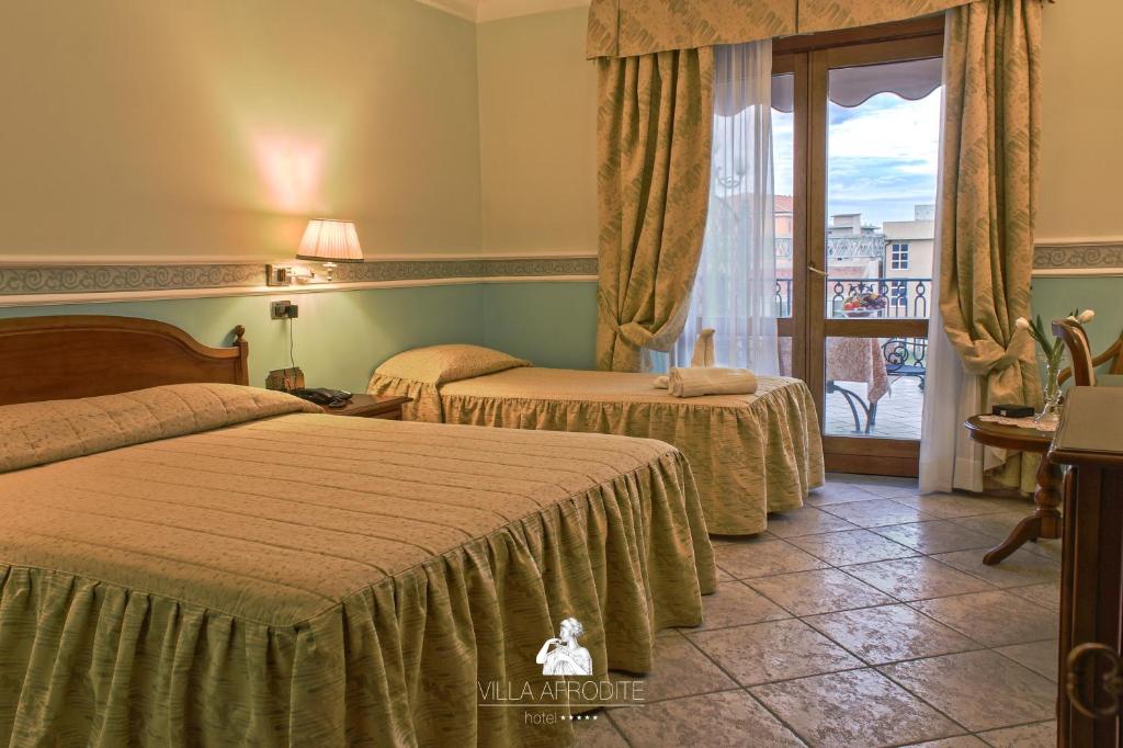 une chambre d'hôtel avec deux lits et un balcon dans l'établissement Afrodite Boutique Hotel, à Bovalino Marina