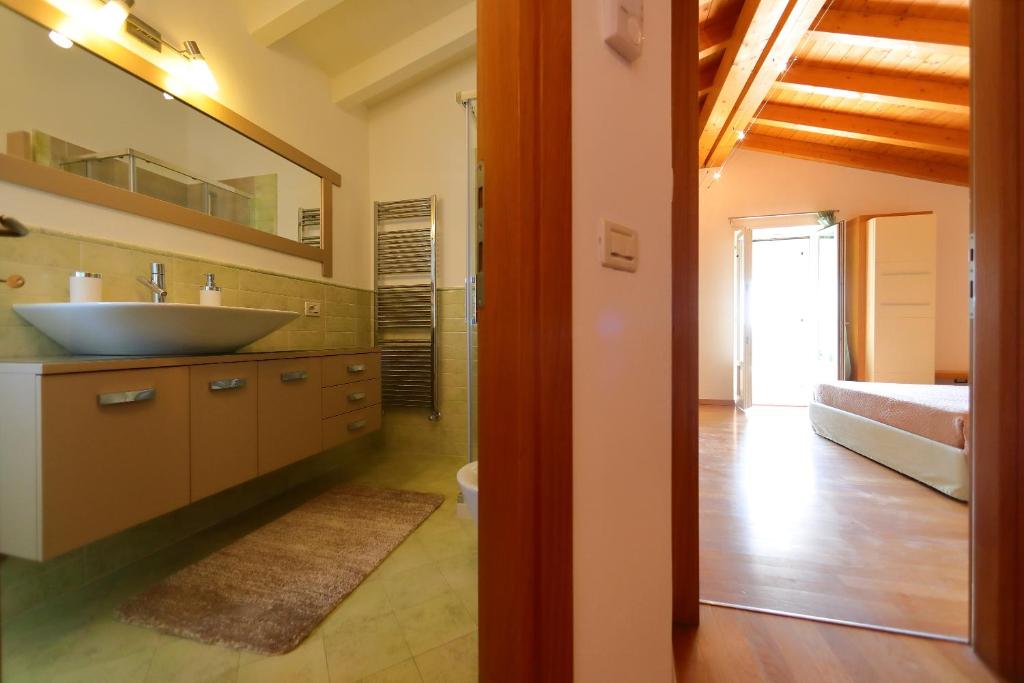 une salle de bain avec un lavabo, un miroir et un lit dans l'établissement Villa Zarina - ZAvillas - up to 12 people, à Peschiera del Garda
